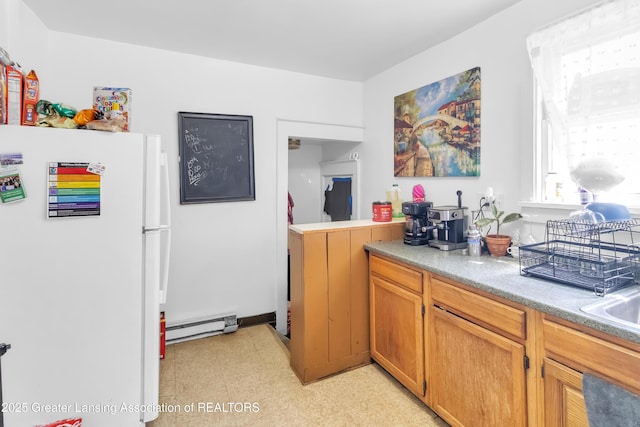 922 Dakin St, Lansing, MI 48912 - kitchen with freestanding refrigerator, light flooring, a baseboard radiator, light countertops, and brown cabinets