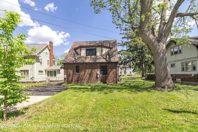514 W St, Lansing, MI 48915 - back of house with brick siding, a lawn, and driveway