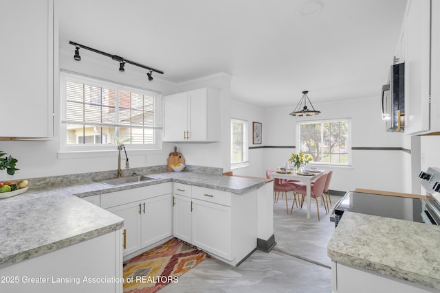 514 W St, Lansing, MI 48915 - kitchen featuring a sink, stainless steel microwave, white cabinetry, and light countertops