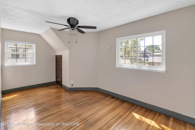 514 W St, Lansing, MI 48915 - empty room featuring wood finished floors, baseboards, ceiling fan, and lofted ceiling