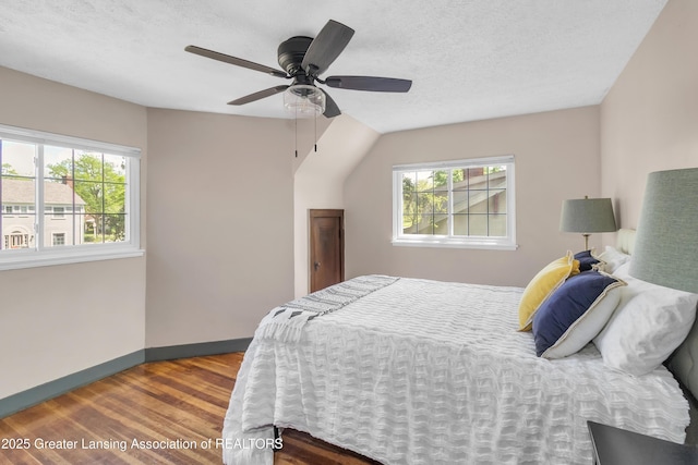 514 W St, Lansing, MI 48915 - bedroom with wood finished floors, multiple windows, baseboards, ceiling fan, and a textured ceiling