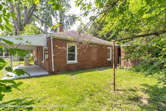 100 Dunlap St, Lansing, MI 48910 - rear view of house featuring brick siding, a chimney, and a patio area