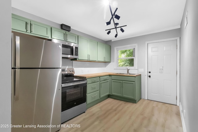 100 Dunlap St, Lansing, MI 48910 - kitchen with green cabinets, appliances with stainless steel finishes, a sink, and crown molding