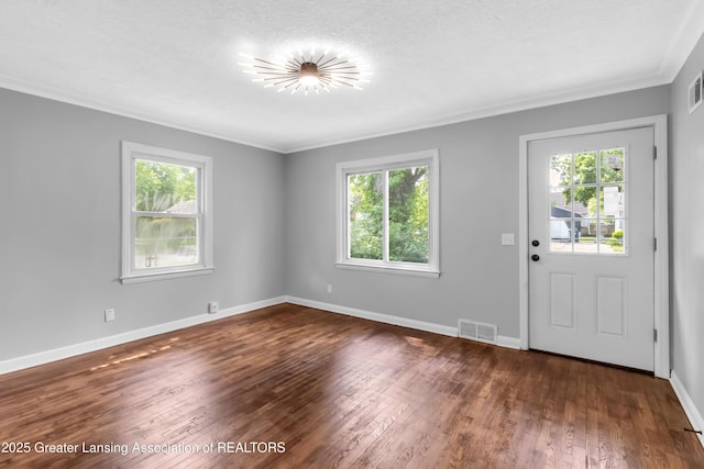 100 Dunlap St, Lansing, MI 48910 - entryway with healthy amount of natural light, dark wood-type flooring, baseboards, crown molding, and a textured ceiling