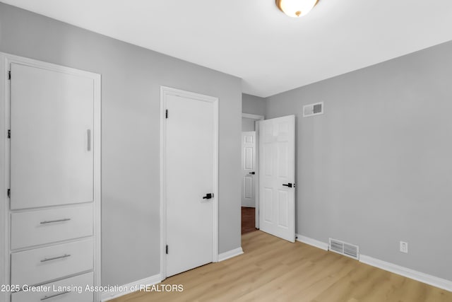 100 Dunlap St, Lansing, MI 48910 - unfurnished bedroom with wood finished floors and baseboards