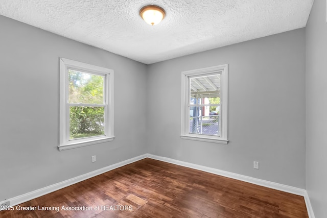 100 Dunlap St, Lansing, MI 48910 - empty room with dark wood finished floors, baseboards, and a textured ceiling