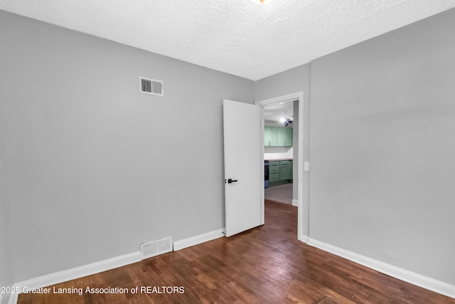 100 Dunlap St, Lansing, MI 48910 - spare room with wood finished floors, baseboards, and a textured ceiling