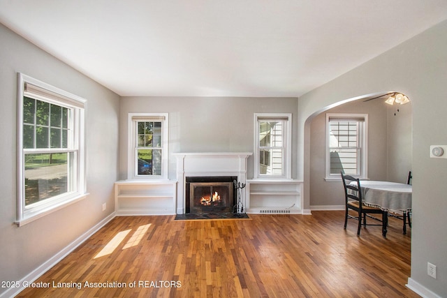 2119 Grant St, Lansing, MI 48910 - living area with wood finished floors, arched walkways, and baseboards