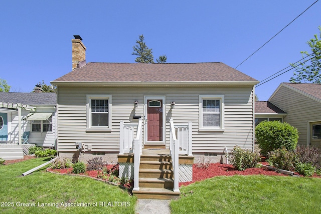 2119 Grant St, Lansing, MI 48910 - view of front of home with a front lawn, roof with shingles, and a chimney