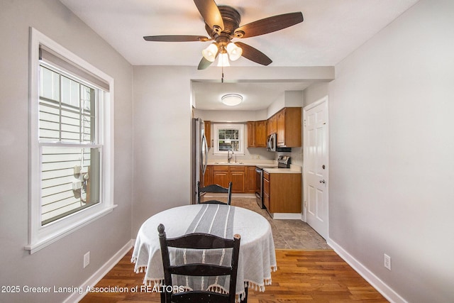 2119 Grant St, Lansing, MI 48910 - kitchen featuring appliances with stainless steel finishes, a sink, brown cabinets, light countertops, and baseboards