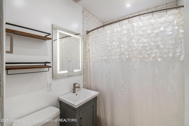 2119 Grant St, Lansing, MI 48910 - bathroom with toilet, vanity, and a shower with shower curtain
