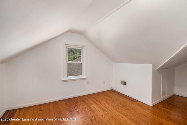 2119 Grant St, Lansing, MI 48910 - additional living space with wood finished floors, vaulted ceiling, and baseboards