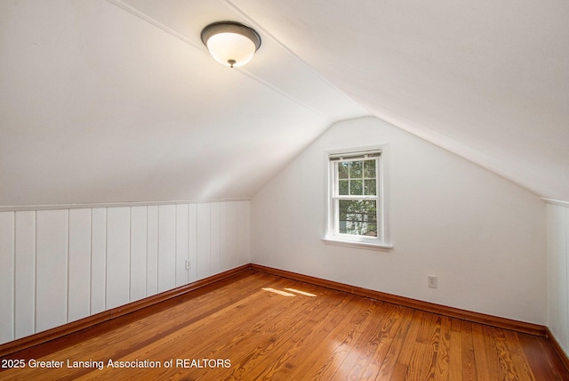 2119 Grant St, Lansing, MI 48910 - additional living space with wood finished floors, vaulted ceiling, and baseboards