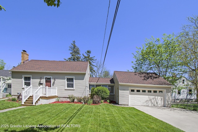 2119 Grant St, Lansing, MI 48910 - cape cod house with concrete driveway, a front yard, a garage, and a chimney