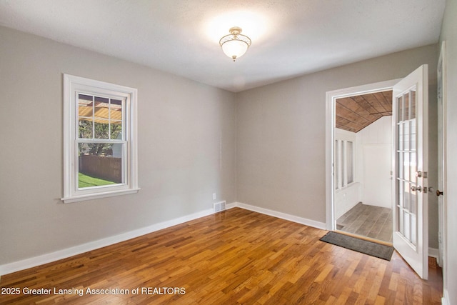 2119 Grant St, Lansing, MI 48910 - empty room featuring light wood-style flooring, french doors, and baseboards