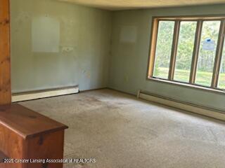 unfurnished room featuring a baseboard radiator and carpet flooring