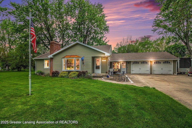12197 W Greenfield Rd, Lansing, MI 48917 - view of front of home with an attached garage, driveway, a chimney, and a front yard