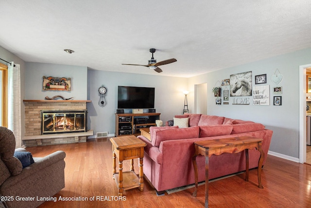 12197 W Greenfield Rd, Lansing, MI 48917 - living area with a ceiling fan, wood finished floors, baseboards, and a brick fireplace
