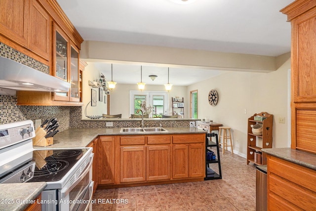 12197 W Greenfield Rd, Lansing, MI 48917 - kitchen with white electric stove, a sink, a peninsula, brown cabinetry, and decorative backsplash
