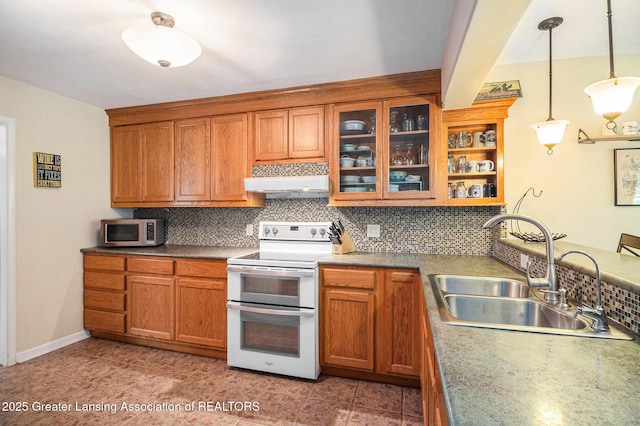 12197 W Greenfield Rd, Lansing, MI 48917 - kitchen with double oven range, stainless steel microwave, a sink, and decorative backsplash