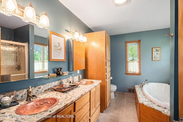 12197 W Greenfield Rd, Lansing, MI 48917 - full bath with tile patterned flooring, a garden tub, a shower stall, double vanity, and toilet