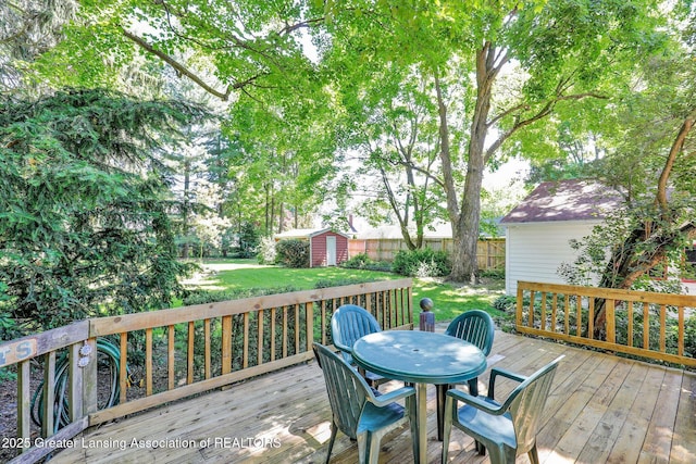 411 Jackson St, Grand Ledge, MI 48837 - wooden terrace featuring a storage shed, an outdoor structure, and outdoor dining space