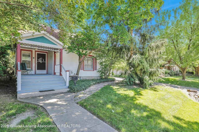 411 Jackson St, Grand Ledge, MI 48837 - view of front of house featuring a front lawn and covered porch