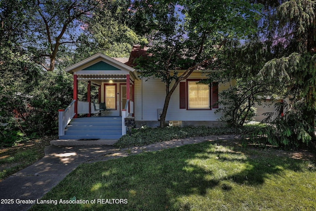 411 Jackson St, Grand Ledge, MI 48837 - view of front of home with covered porch and a front yard