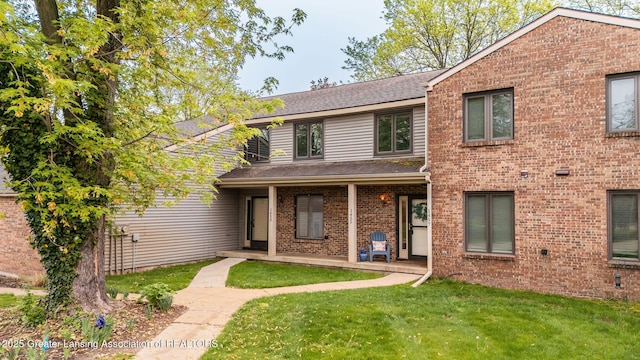 1455 Lakeside Dr, East Lansing, MI 48823 - traditional home featuring a front yard, a shingled roof, and brick siding