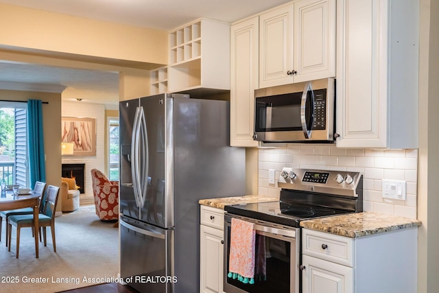 1455 Lakeside Dr, East Lansing, MI 48823 - kitchen with appliances with stainless steel finishes, tasteful backsplash, light colored carpet, light stone countertops, and white cabinets