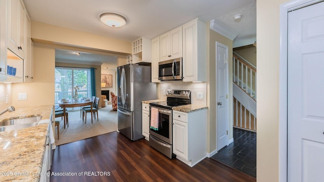 1455 Lakeside Dr, East Lansing, MI 48823 - kitchen featuring stainless steel appliances, a sink, dark wood finished floors, backsplash, and white cabinets