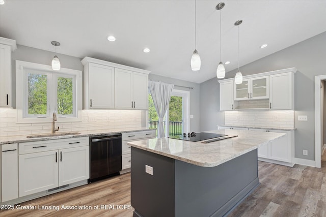 15426 S Lowell Rd, Lansing, MI 48906 - kitchen with dishwashing machine, a sink, black electric stovetop, white cabinetry, and lofted ceiling
