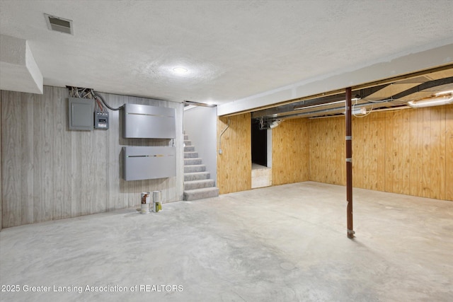 15426 S Lowell Rd, Lansing, MI 48906 - finished basement with stairs, a textured ceiling, wooden walls, and electric panel