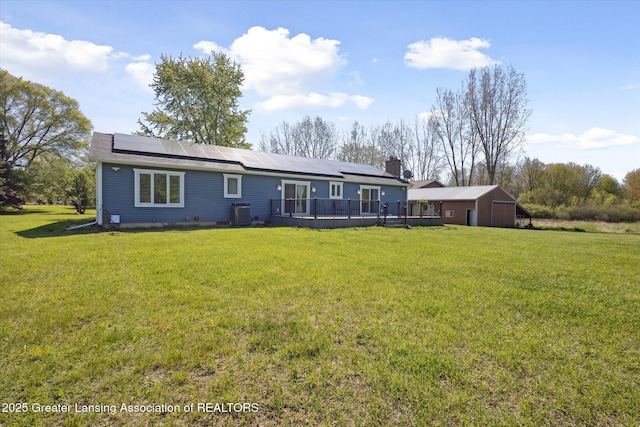 15426 S Lowell Rd, Lansing, MI 48906 - rear view of property with a wooden deck, a yard, and roof mounted solar panels