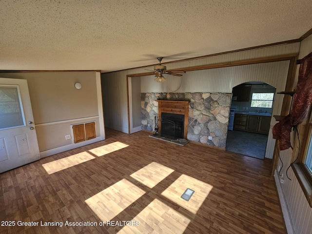 6815 Aurelius Rd, Lansing, MI 48911 - unfurnished living room with a textured ceiling, ceiling fan, a stone fireplace, ornamental molding, and wood finished floors