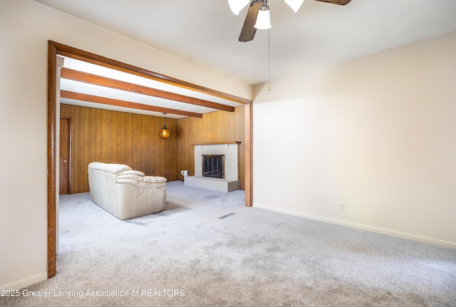 3316 Pickwick Pl, Lansing, MI 48917 - unfurnished living room featuring carpet floors, ceiling fan, beam ceiling, wood walls, and a brick fireplace