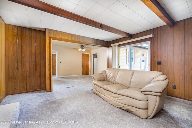 3316 Pickwick Pl, Lansing, MI 48917 - living room featuring beamed ceiling, wooden walls, light carpet, and baseboards