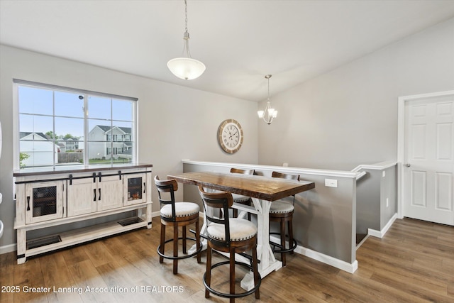1123 Chesham Ln, Grand Ledge, MI 48837 - dining area featuring dark wood-type flooring, baseboards, and a chandelier