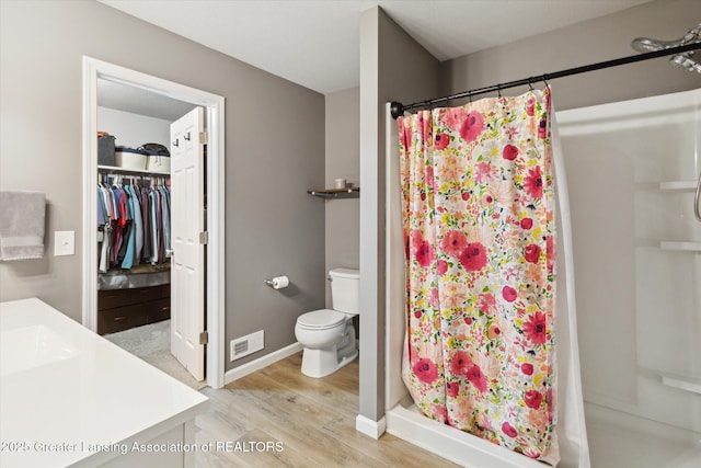1123 Chesham Ln, Grand Ledge, MI 48837 - full bath featuring a stall shower, wood finished floors, toilet, vanity, and baseboards