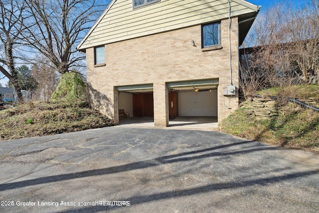 4794 Ardmore Ave, Okemos, MI 48864 - view of side of property with an attached garage, asphalt driveway, and brick siding