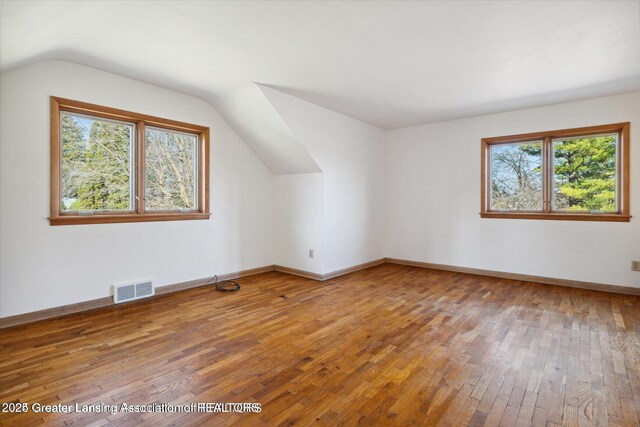 4794 Ardmore Ave, Okemos, MI 48864 - additional living space with healthy amount of natural light, wood-type flooring, lofted ceiling, and baseboards
