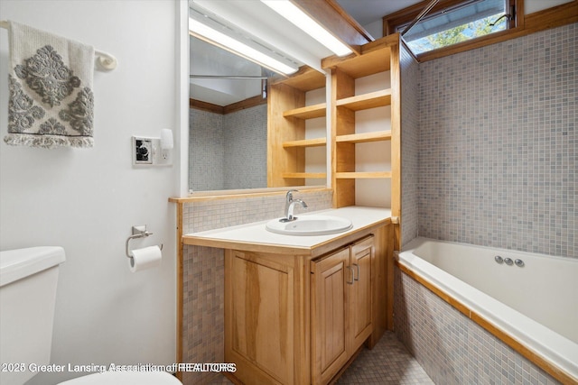 4794 Ardmore Ave, Okemos, MI 48864 - full bathroom with toilet, tiled tub, tasteful backsplash, vanity, and tile patterned floors