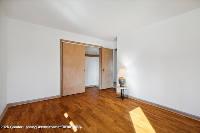4794 Ardmore Ave, Okemos, MI 48864 - unfurnished bedroom featuring wood finished floors, baseboards, and a closet