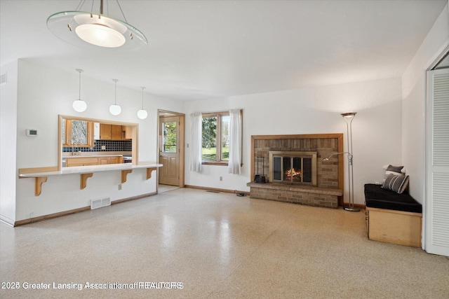 4794 Ardmore Ave, Okemos, MI 48864 - unfurnished living room with a brick fireplace and baseboards