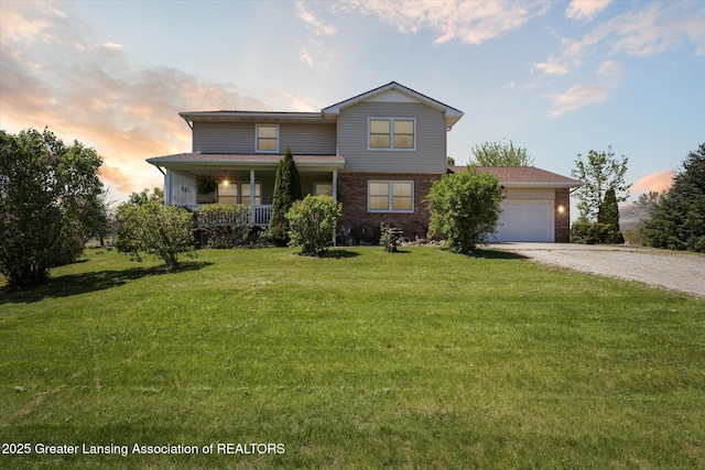 12898 Walker Rd, Leslie, MI 49251 - traditional home featuring gravel driveway, a yard, brick siding, and a garage