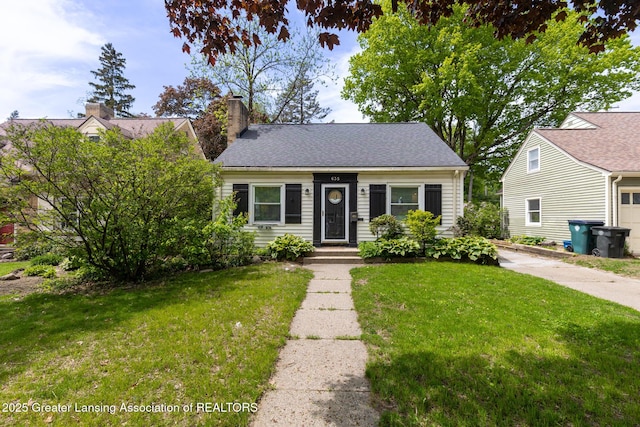 635 Division St, East Lansing, MI 48823 - view of front of home featuring a front yard and a chimney