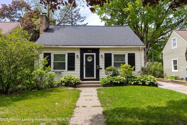 635 Division St, East Lansing, MI 48823 - view of front facade with a chimney, a front lawn, and roof with shingles