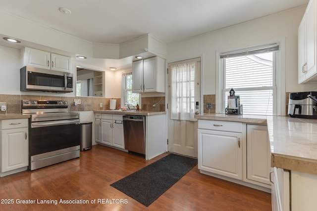 635 Division St, East Lansing, MI 48823 - kitchen with appliances with stainless steel finishes, backsplash, and white cabinetry