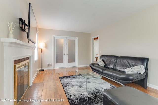 635 Division St, East Lansing, MI 48823 - living area with french doors, wood finished floors, baseboards, and a tile fireplace