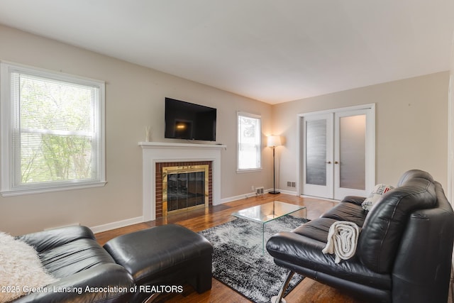 635 Division St, East Lansing, MI 48823 - living area with french doors, healthy amount of natural light, a fireplace, and baseboards
